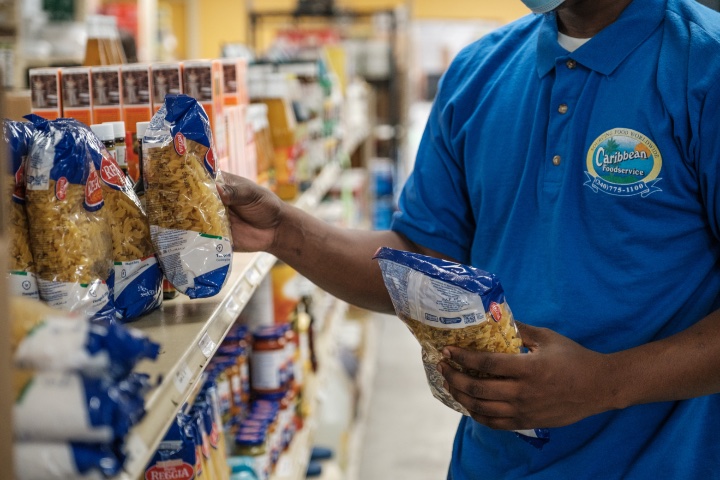Caribbean Foodservice team member selecting pasta from fully stocked shelves